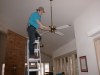 Kevin wipes down ceiling fan body and blades along with inside window cleaning.