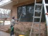 Tim uses an extension pole to squeegee dry windows after first scrubbing the glass, frames and proximities.