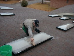 Shaun carefully scrubs skylight with a soft bristle brush and acetic wash solution.