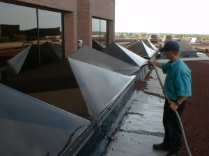 Shaun begins the skylight cleaning process by gently flushing off as much dirt as possible before scrubbing.